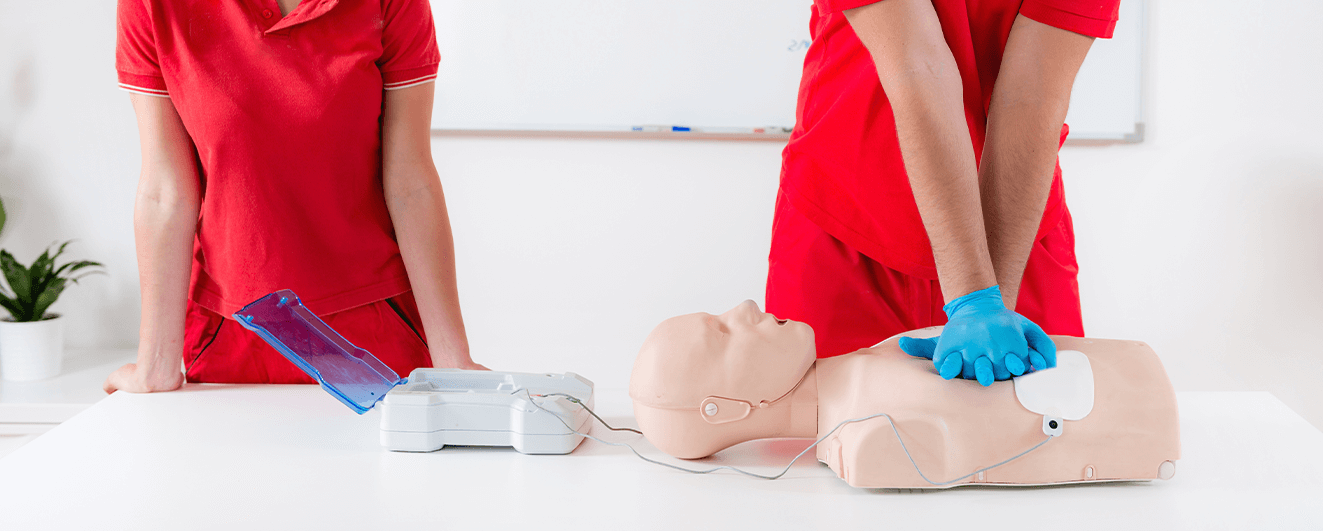 First Aid Teaching showing how to use defibrillator on CPR dummy